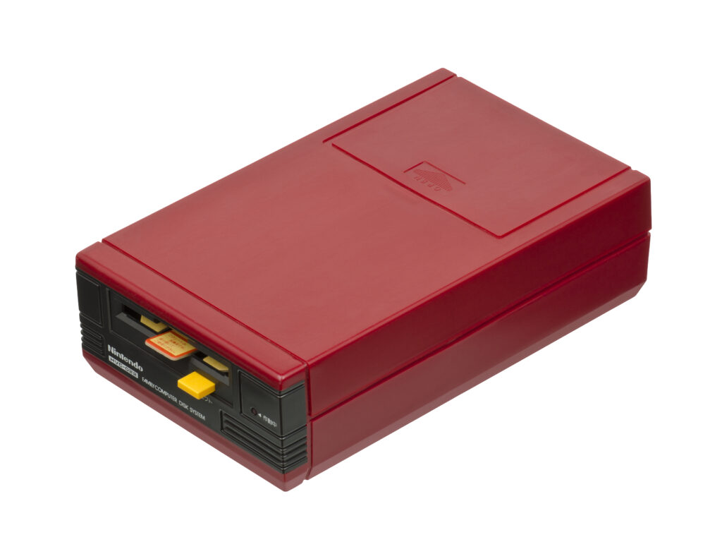 Famicom Disk System avec une Disk Card jaune partiellement ins&eacute;r&eacute;e